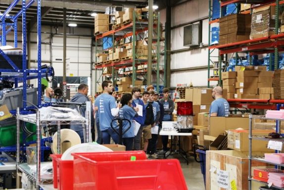 El supervisor de producción, Jacob, explica el proceso de fabricación de luces de obstrucción de xenón y LED a los estudiantes en el Día de la fabricación 2018