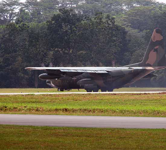 Un C-130 en un campo de camisetas con luces de calle de rodaje