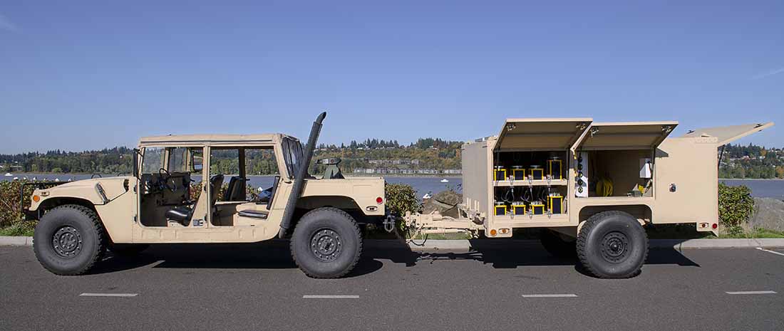 Une remorque du système d'éclairage de l'aérodrome expéditionnaire (EALS) raccordée à un Humvee