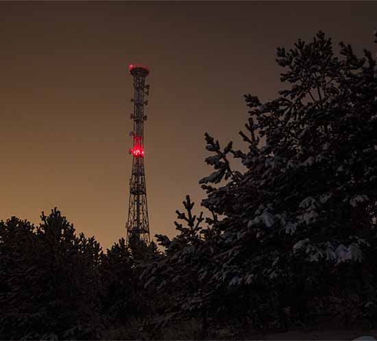 Estructura de comunicaciones con torre de luz roja por la noche