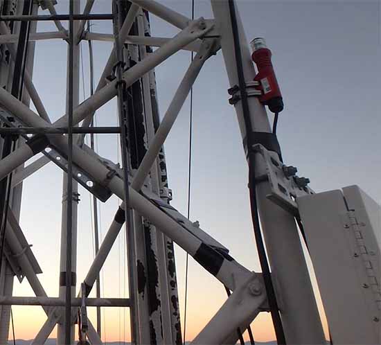 Una luz de obstrucción L-810 o una luz de posición lateral en una pata de la torre